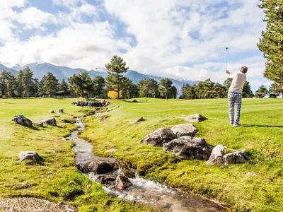 a man is playing golf on a golf course at FEDORA - Luxury Penthouse in Pirin Golf & SPA in Razlog