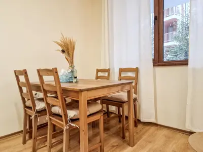 a dining room table with chairs and a window at Relaxing Stay in Kosara Bansko Near Ski Lift by Flat Mаnager in Bansko