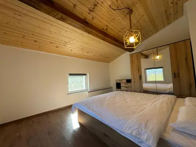 a bedroom with a bed and a wooden ceiling at Вила Mountain Ship in Dedovo