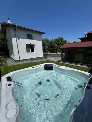a hot tub in the backyard of a house at Вила Mountain Ship in Dedovo