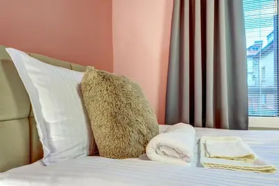 a bed with white pillows and towels on it at Апартамент за гости Райково in Smolyan