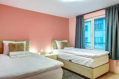 two beds in a room with a window at Апартамент за гости Райково in Smolyan