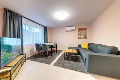 a living room with a blue couch and a tv at Апартамент за гости Райково in Smolyan
