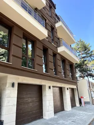 a house with two garage doors in front of it at Atayana Apartment in Sofia