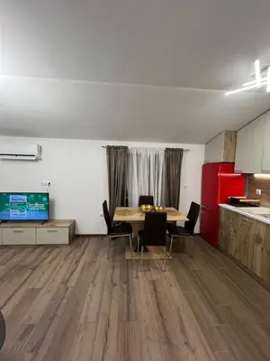 a room with a table and chairs and a kitchen at Atayana Apartment in Sofia