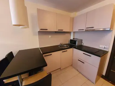 a small kitchen with a black counter top and a sink at Bansko lodge 500m from ski lift in Bansko
