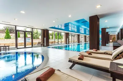 a swimming pool with two lounges in a hotel at Bansko lodge 500m from ski lift in Bansko