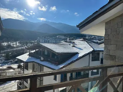 a view from the balcony of a building with snow on the roof at Двустаен апартамент 