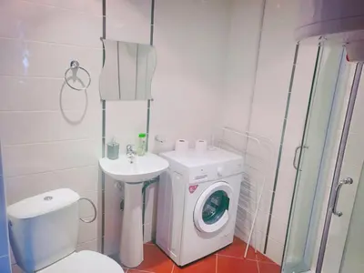 a bathroom with a washing machine and a washer at Двустаен апартамент 