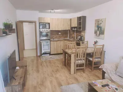 a living room with a table and a kitchen at Двустаен апартамент 