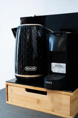 a black toaster sitting on top of a wooden stand at Host2U Highland Hideaway Bansko in Bansko