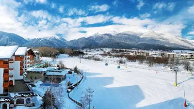 a snow covered ski slope with mountains in the background at Host2U Highland Hideaway Bansko in Bansko