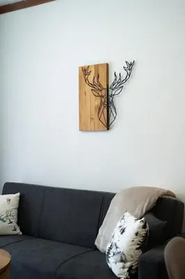 a black couch against a white wall with a wooden picture at Host2U Highland Hideaway Bansko in Bansko