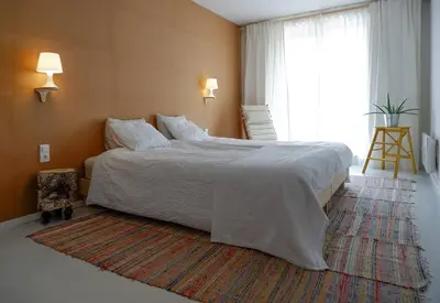 a bedroom with a large bed and a large window at Host2U Art AP - Fireplace - Free parking - 5min Gondola in Bansko