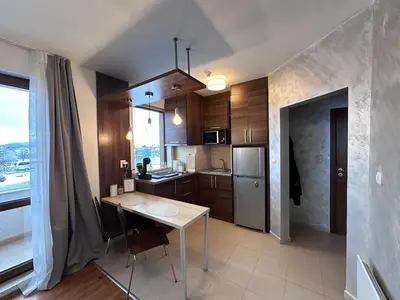 a kitchen with a table and a kitchen with a window at Host2U Belvedere Apartment - Ski in - out - FREE Parking in Bansko