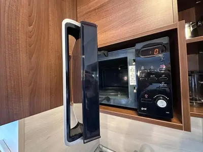 a microwave oven in a kitchen with its door open at Host2U Belvedere Apartment - Ski in - out - FREE Parking in Bansko