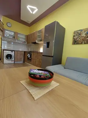 a kitchen with a couch and a bowl on the floor at Tranquility Lodge, next to Paradise and metro station in Sofia