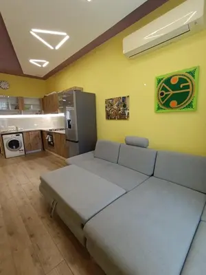 a living room with a couch and a kitchen at Tranquility Lodge, next to Paradise and metro station in Sofia