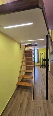 a staircase in a room with green walls and wooden floors at Tranquility Lodge, next to Paradise and metro station in Sofia