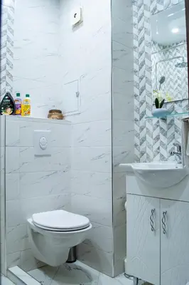 a white bathroom with a toilet and a sink at HD Comfort Apartment in Sofia