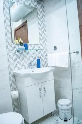 a white bathroom with a sink and a toilet at HD Comfort Apartment in Sofia