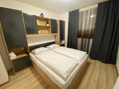 a small bedroom with a white bed and shelves at Castle Inn Pamporovo in Pamporovo