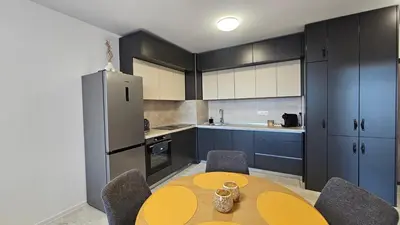 a kitchen with a table and chairs and a refrigerator at Stylish and Modern 1bdrm apt free private parking in Sofia