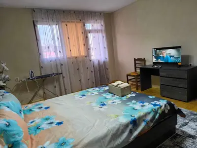 a bedroom with a bed with blue flowers on it at Апартамент Котеви in Sandanski