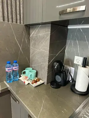 a kitchen counter with two bottles of water and cups at West Point Luxury studio in Plovdiv