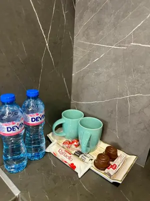 two bottles of water and cups and donuts on a table at West Point Luxury studio in Plovdiv