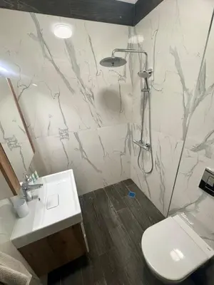 a bathroom with a shower and a toilet and a sink at West Point Luxury studio in Plovdiv