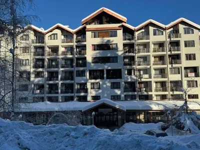 a large apartment building with snow in front of it at Borovetz Gardens MVS Apart E28 in Borovets