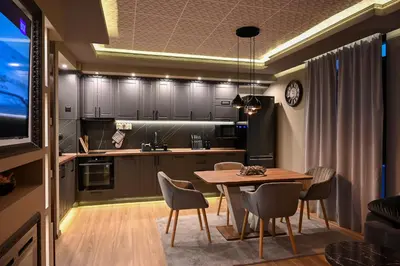 a kitchen and dining room with a table and chairs at All Seasons Apartment in Sofia