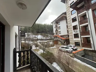 a balcony of a apartment building with a car parked at Balkan Heights Apartment in Bansko