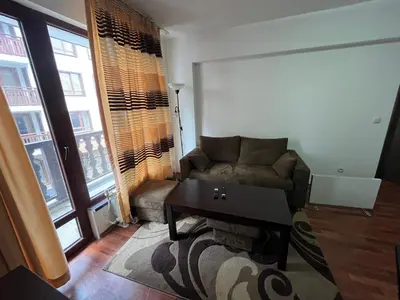 a living room with a couch and a table at Balkan Heights Apartment in Bansko