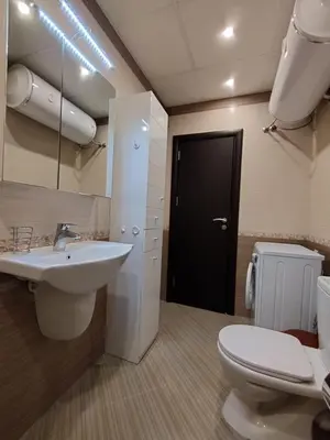 a bathroom with a sink and a toilet and a black door at Апартамент Сандански Център in Sandanski
