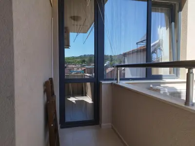 a balcony with a glass door and a basketball hoop at Апартамент Сандански Център in Sandanski