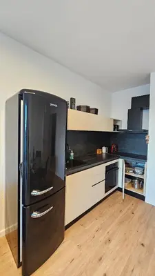 a kitchen with a black refrigerator in a room at Cozy Urban Heaven with Dedicated Parking Spot in Sofia