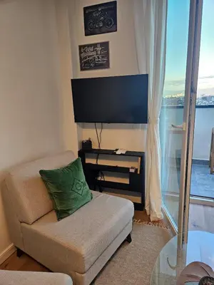 a living room with a couch and a flat screen tv at Cozy Urban Heaven with Dedicated Parking Spot in Sofia