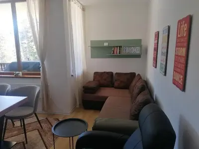 a living room with a couch and a table at ИН Хоум Комфорт in Borovets