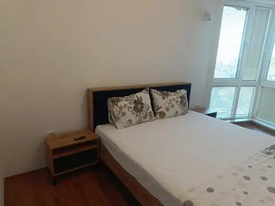 a bedroom with a bed with a pillow and two windows at Two-bedroom Apartment Lauta 28 in Plovdiv