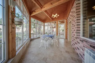 a screened in porch with a table and chairs at The Exquisite Residence in Zheleznitsa