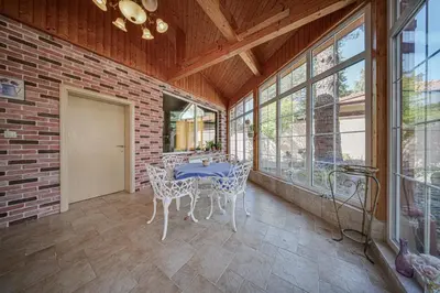 a dining room with a table and chairs and windows at The Exquisite Residence in Zheleznitsa