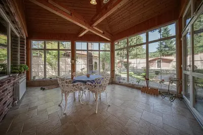 a dining room with a table and chairs in a room with windows at The Exquisite Residence in Zheleznitsa
