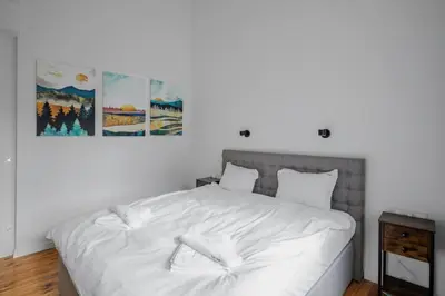 a bedroom with a white bed with two paintings on the wall at Luminous Central Retreat Spacious 2BD Apartment by Flat Mаnager in Sofia