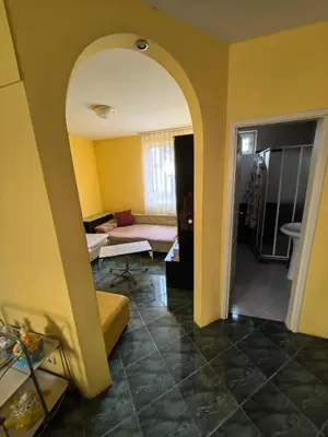 a living room with a yellow wall and a couch at Apartment Tinka in Sofia