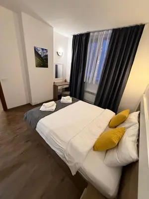 a bedroom with a large white bed with yellow pillows at From Sunrise to Sunset at Oak Residence Smolyan in Smolyan