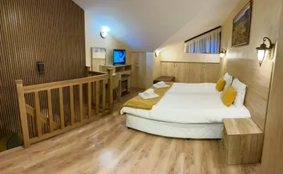 a bedroom with a large bed and a tv in it at From Sunrise to Sunset at Oak Residence Smolyan in Smolyan