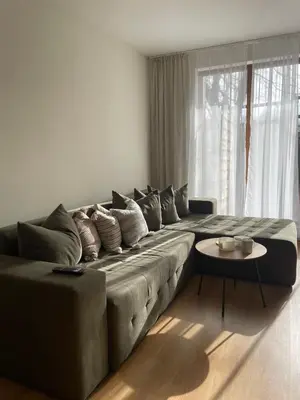 a living room with a large couch and a table at The New Inn in Bansko