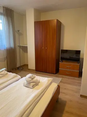 a bedroom with two beds and a wooden cabinet at The New Inn in Bansko